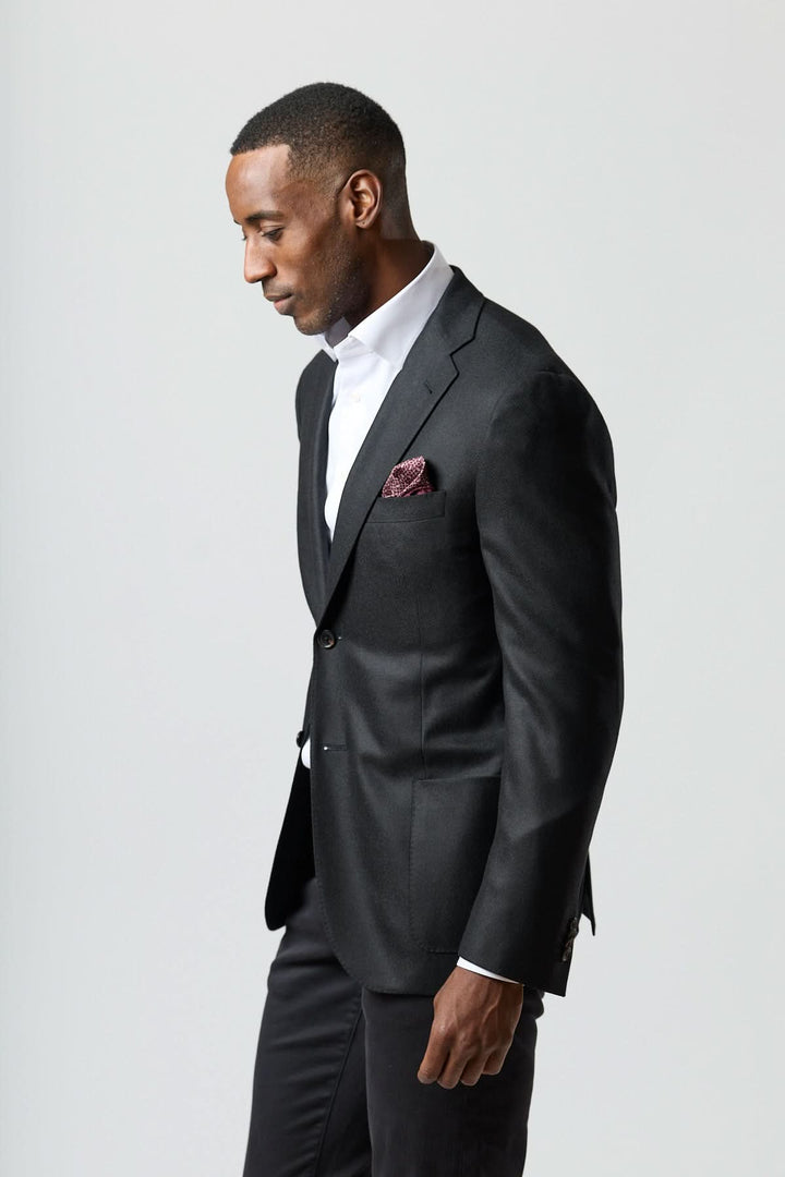 Veston en laine et cachemire noir Corneliani porté avec style, texture satinée, sophistiqué et intemporel pour occasions formelles.