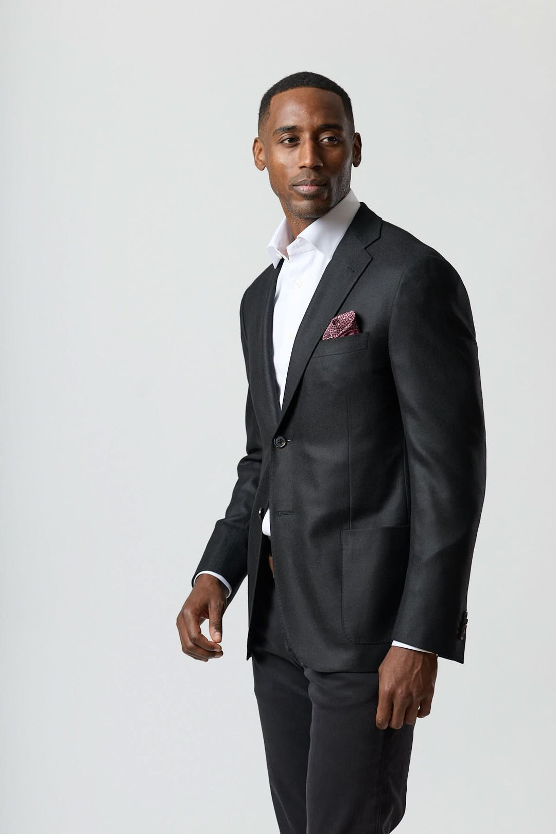 Homme portant un veston en laine et cachemire noir Corneliani avec chemise blanche, élégance italienne classique.