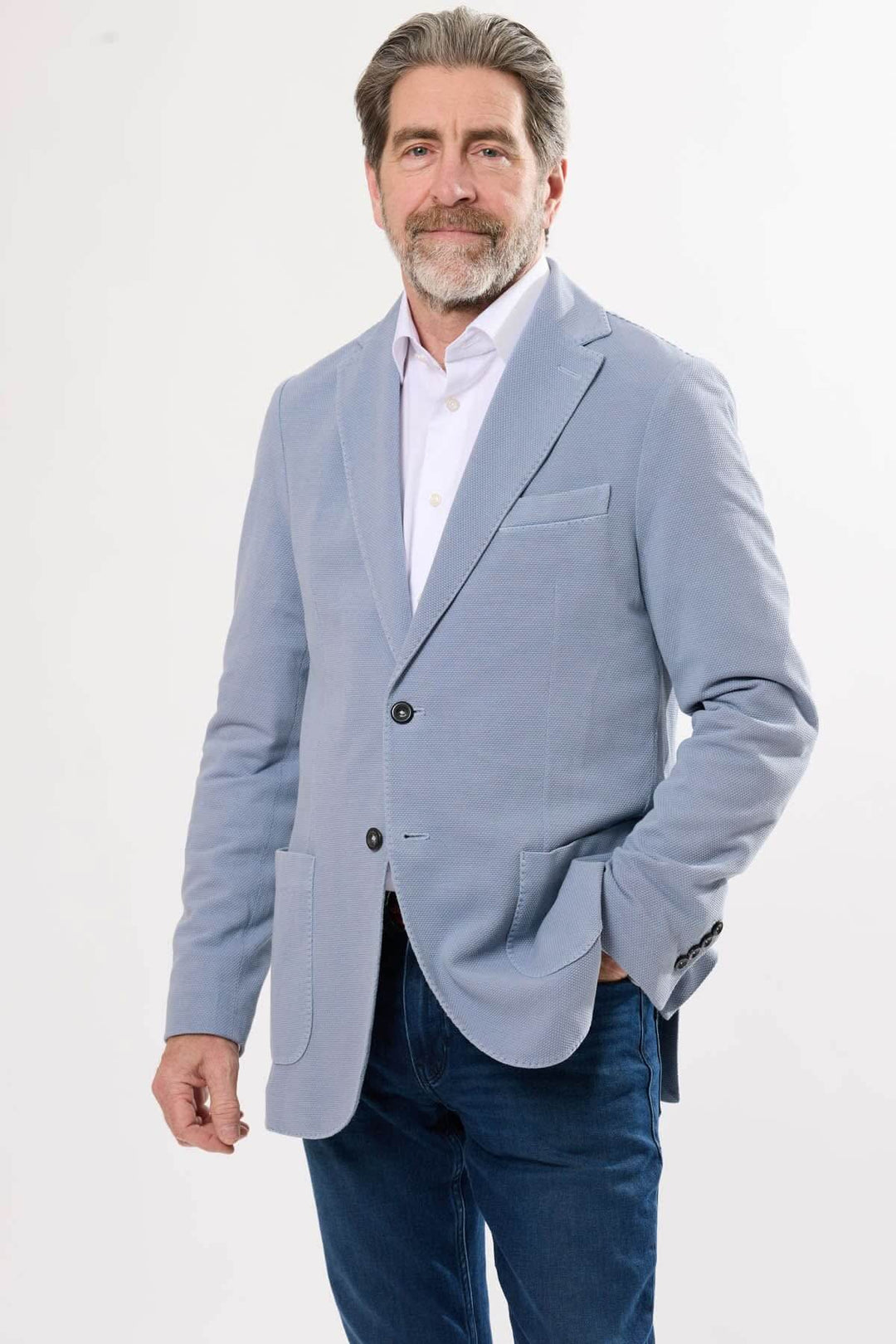 Homme portant un veston en maille texturée bleu, élégant et confortable pour un look chic décontracté.