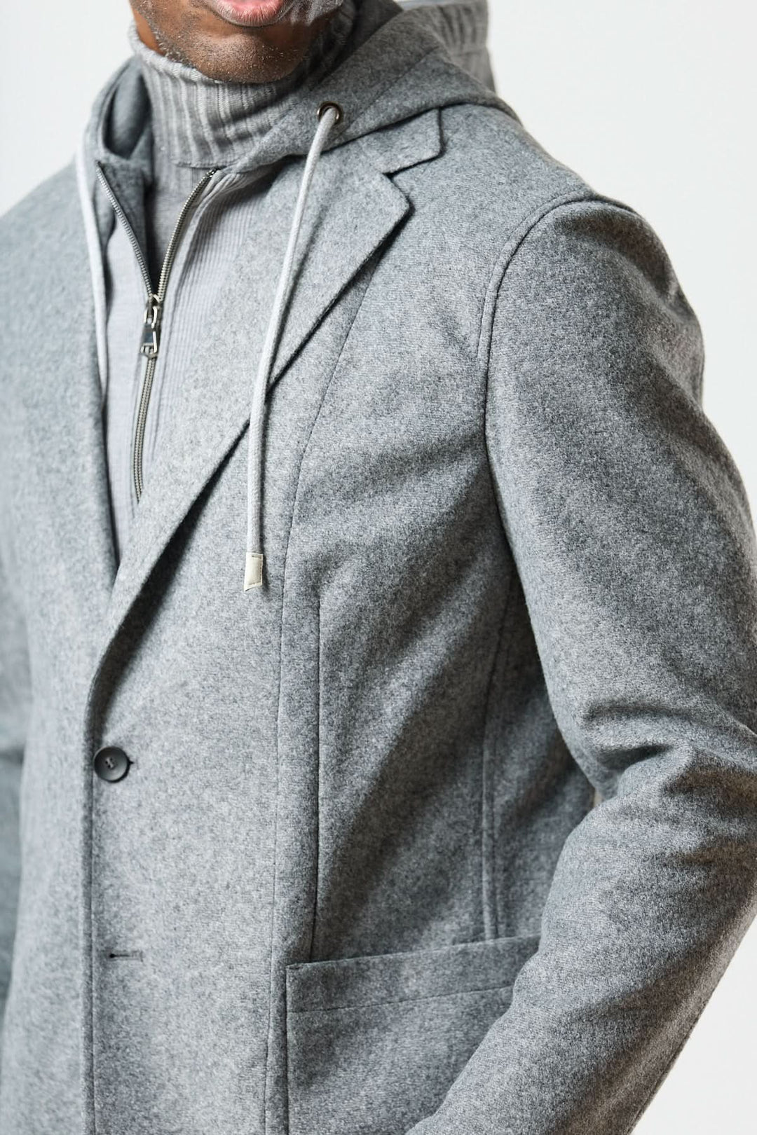 Veston hybride à capuche gris avec capuche intégrée et col roulé pour un look urbain élégant.