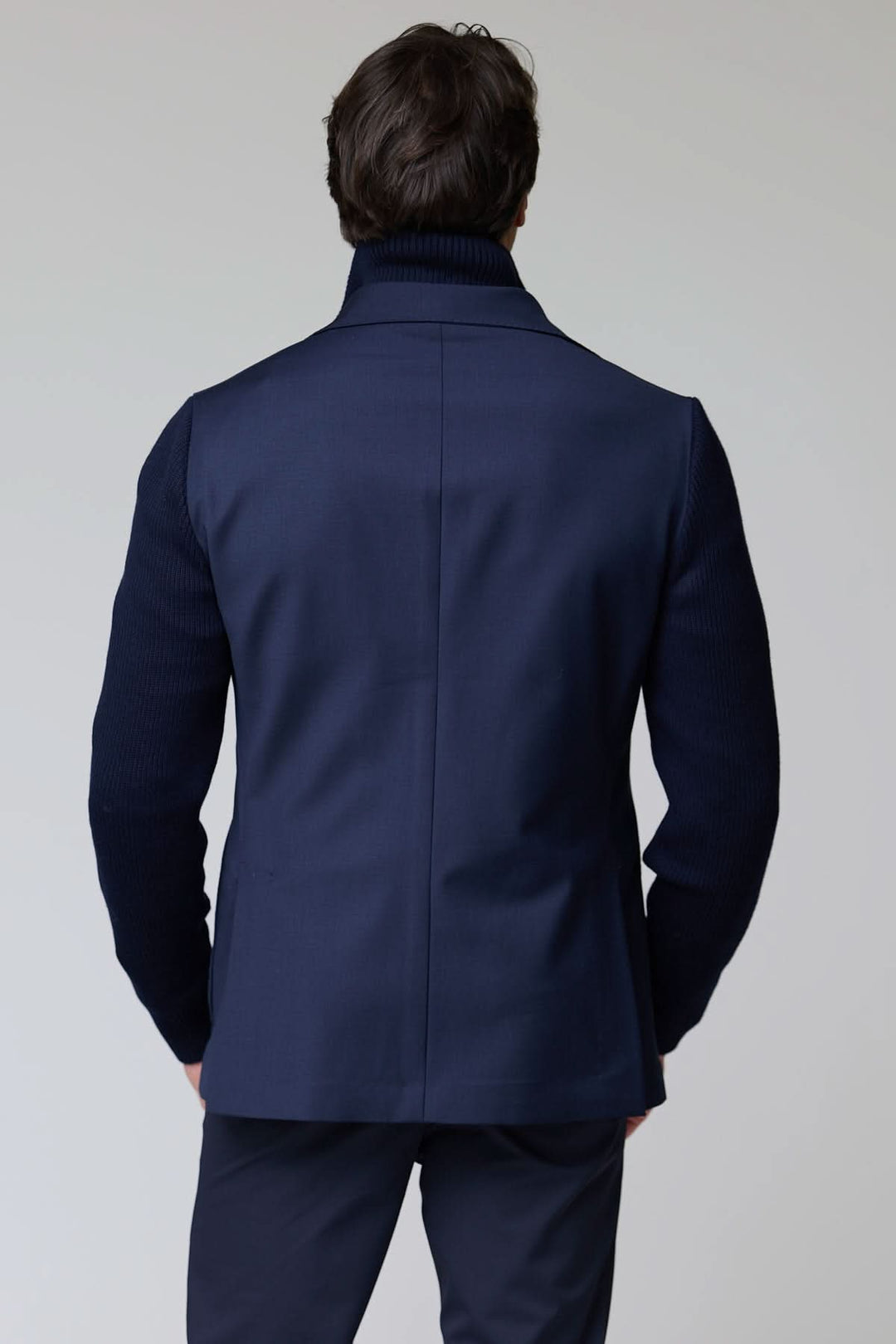 Dos d'un veston hybride tricot et tissu avec manches en maille et col à revers, offrant un style chic et décontracté.