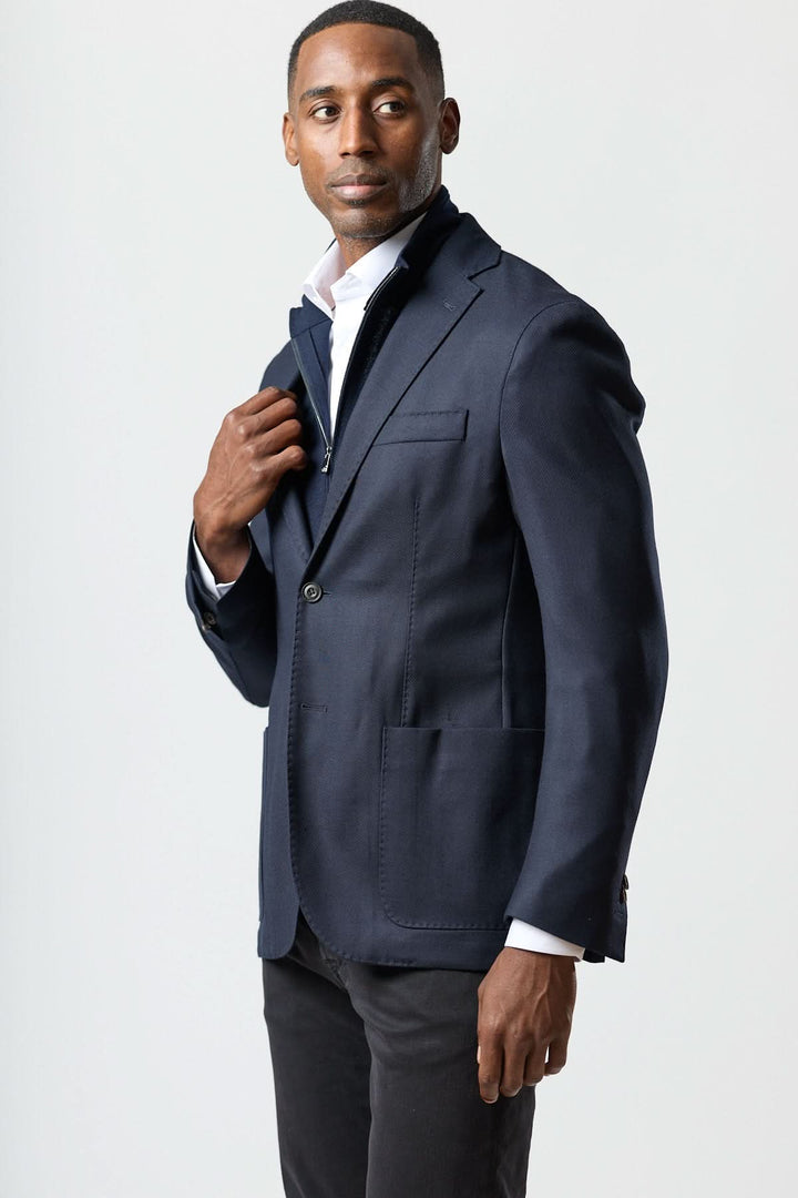Homme portant un veston moderne avec gilet zippé intégré, coupe semi-ajustée, élégance italienne, pour un look raffiné et décontracté.