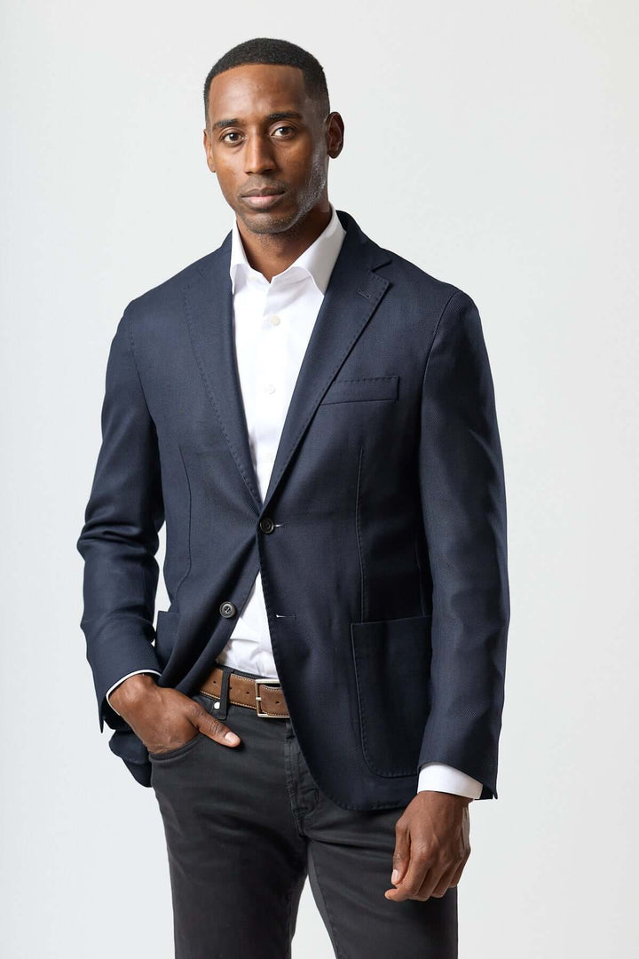 Homme portant un veston moderne avec gilet zippé intégré, élégance italienne et finesse contemporaine.