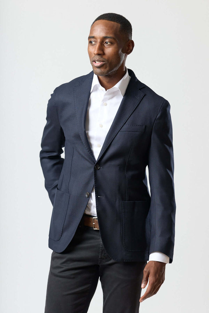 Homme portant un veston moderne avec gilet zippé intégré, élégance italienne style contemporain, veston Corneliani semi-ajusté noir.