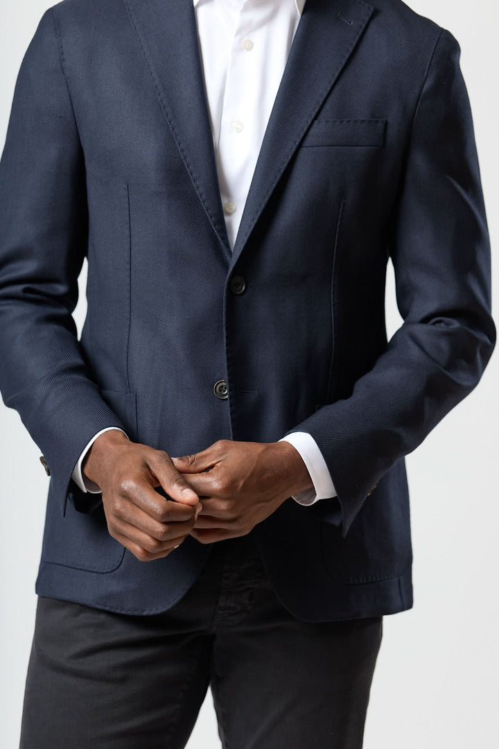 Homme portant un veston moderne avec gilet zippé intégré, élégance italienne, coupe semi-ajustée, look raffiné et décontracté.