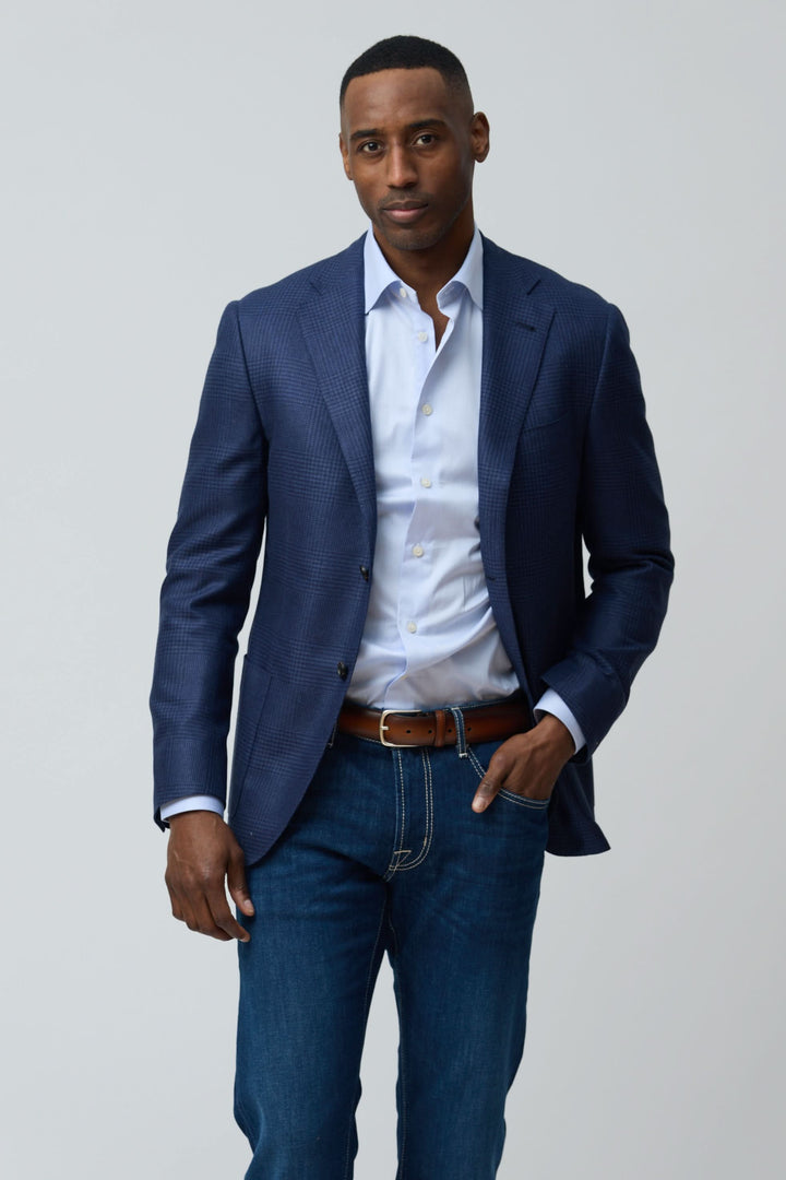 Homme portant un veston structuré à motif subtil avec une chemise blanche et un jean.