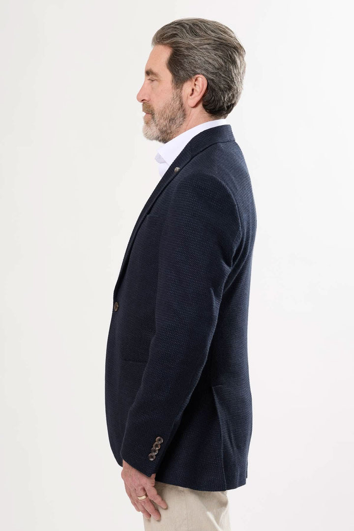 Homme portant un veston texturé élégant, vue de profil, style professionnel, coupe contemporaine.