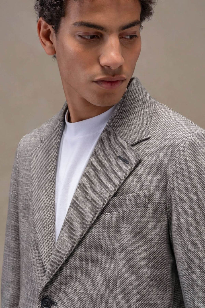 Veston texturé élégant, col à revers avec œillet, polaire extensible, confort et style. Deux boutons en corne. Mode raffinée homme.
