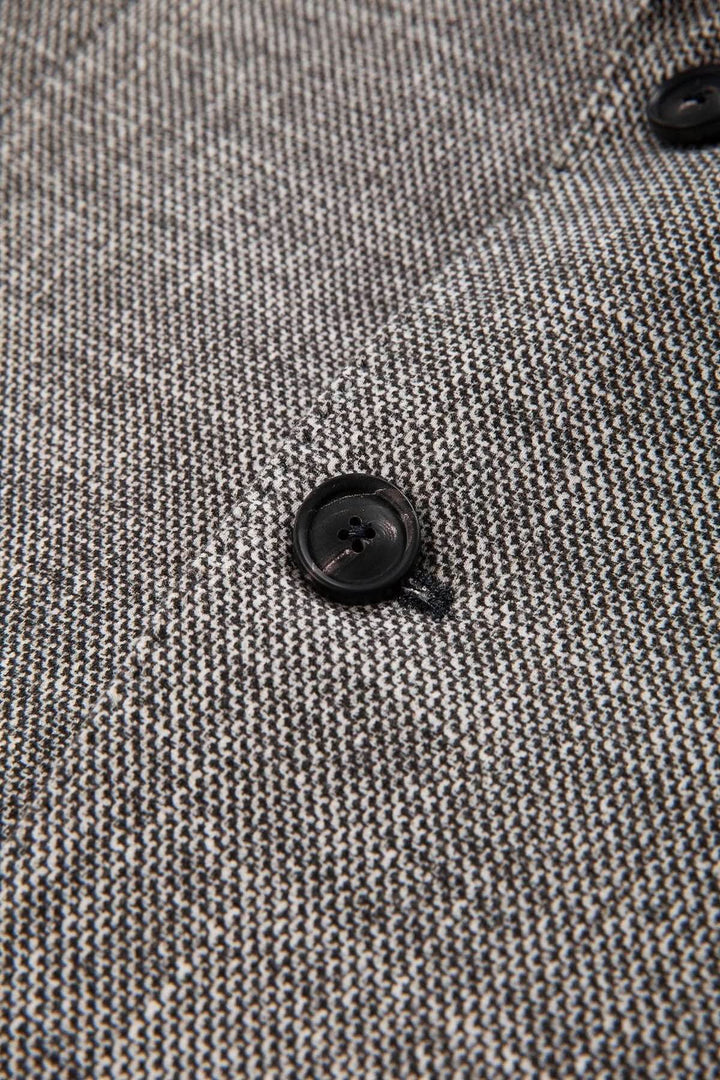 Veston texturé avec boutons en corne, vue rapprochée montrant le tissu et les détails de couture raffinés.