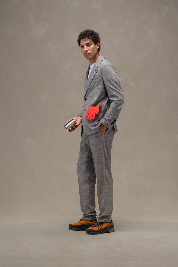 Homme portant un veston texturé gris élégant avec des accessoires atypiques, alliant style raffiné et décontracté.