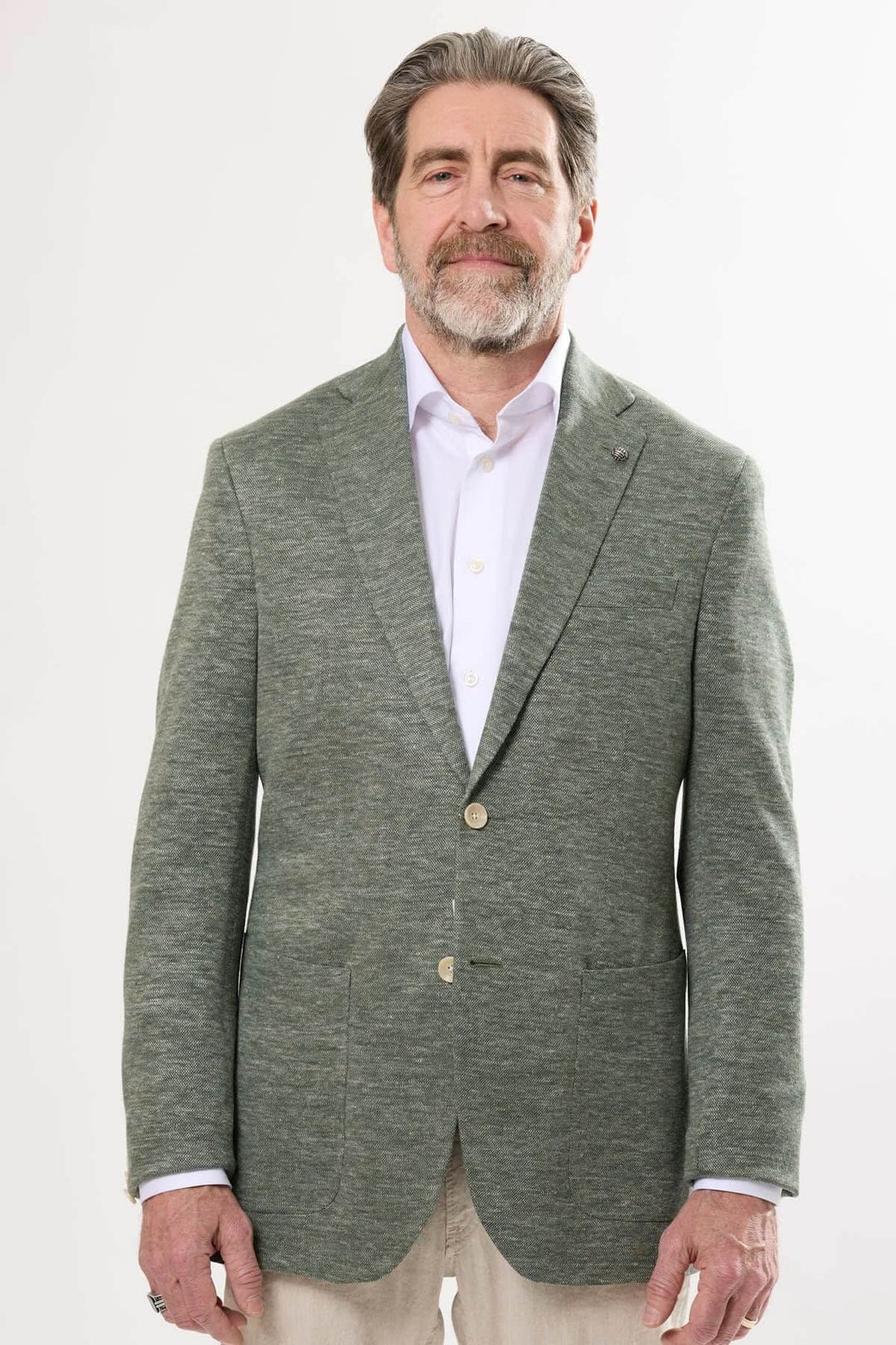 Homme portant un veston texturé vert, élégant et moderne, parfait pour des tenues décontractées chic.
