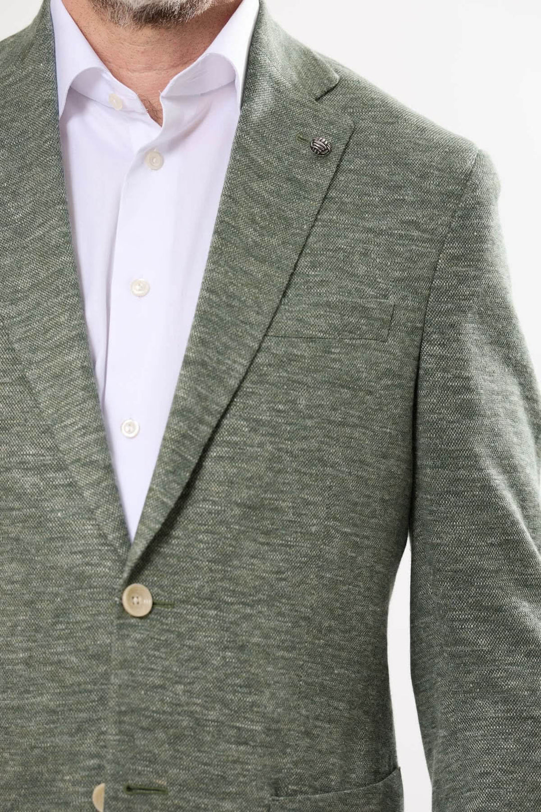 Veston texturé vert en maille souple, avec fermeture à deux boutons et revers cranté, idéal pour un look chic.