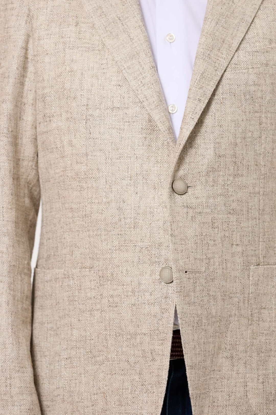 Veston texturé d'été beige, coupe semi-ajustée, associé à une chemise blanche, parfait pour une allure chic.