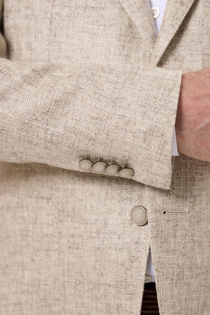 Veston texturé d'été avec boutonnières classiques et manches élégantes sur tissu beige.