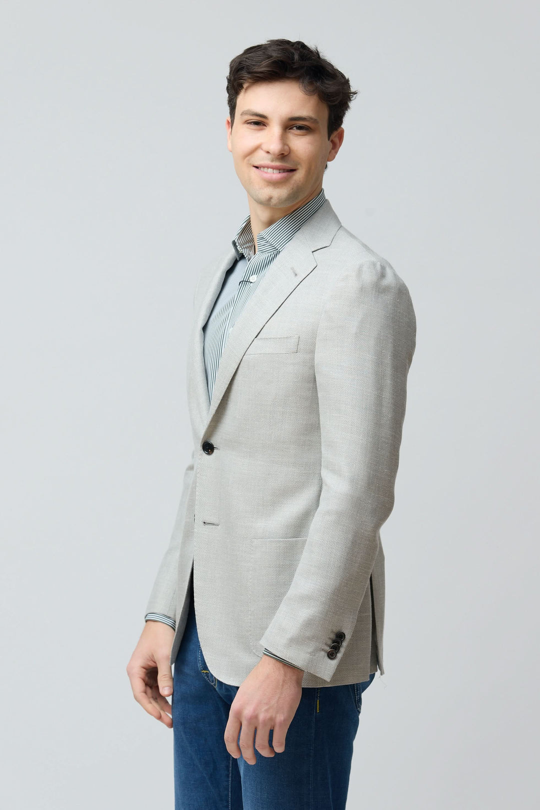Homme portant un veston texturé en laine, soie et lin, coupe ajustée, élégant et contemporain, idéal pour une tenue chic ou habillée.