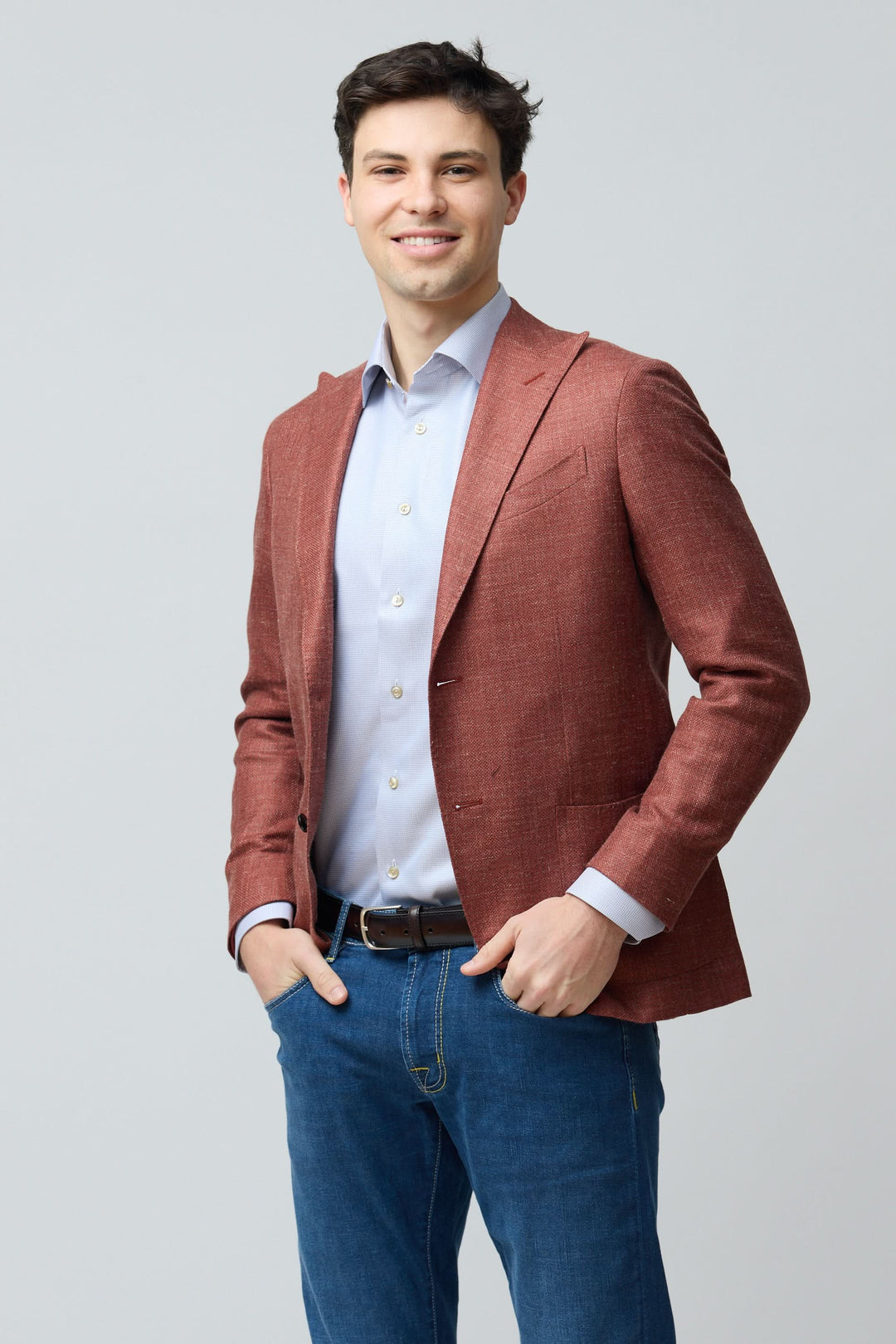 Homme portant un veston texturé en laine, soie et lin rouge, style décontracté chic.