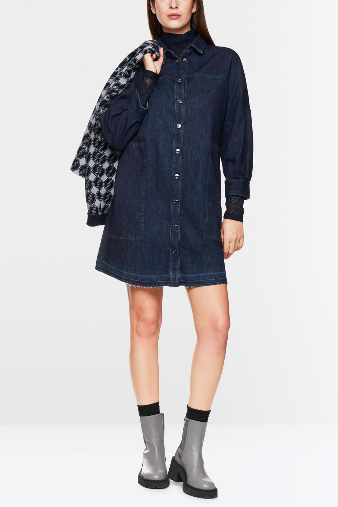 Robe en jean trapèze avec manches bouffantes, portée avec des bottines, style décontracté et moderne.