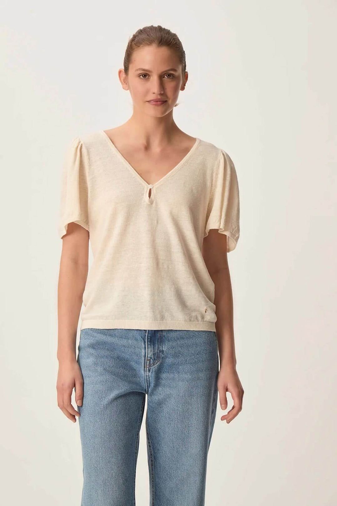 Haut léger à encolure en V, avec manches bouffantes et détail ajouré, parfait pour un style délicat.