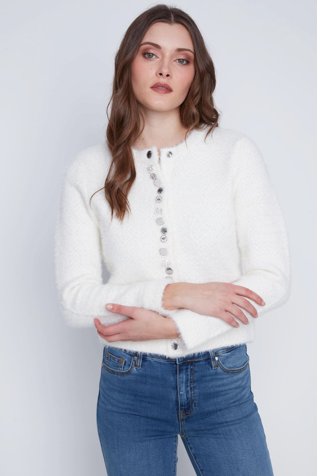 Cardigan doux à manches longues avec boutons décoratifs, coupe courte, porté avec un jean pour un look chic.