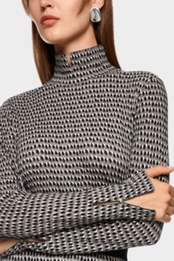 Chandail imprimé pailleté avec col montant et manches longues, motif structuré, porté par un mannequin, tricoté en Allemagne, mode moderne.