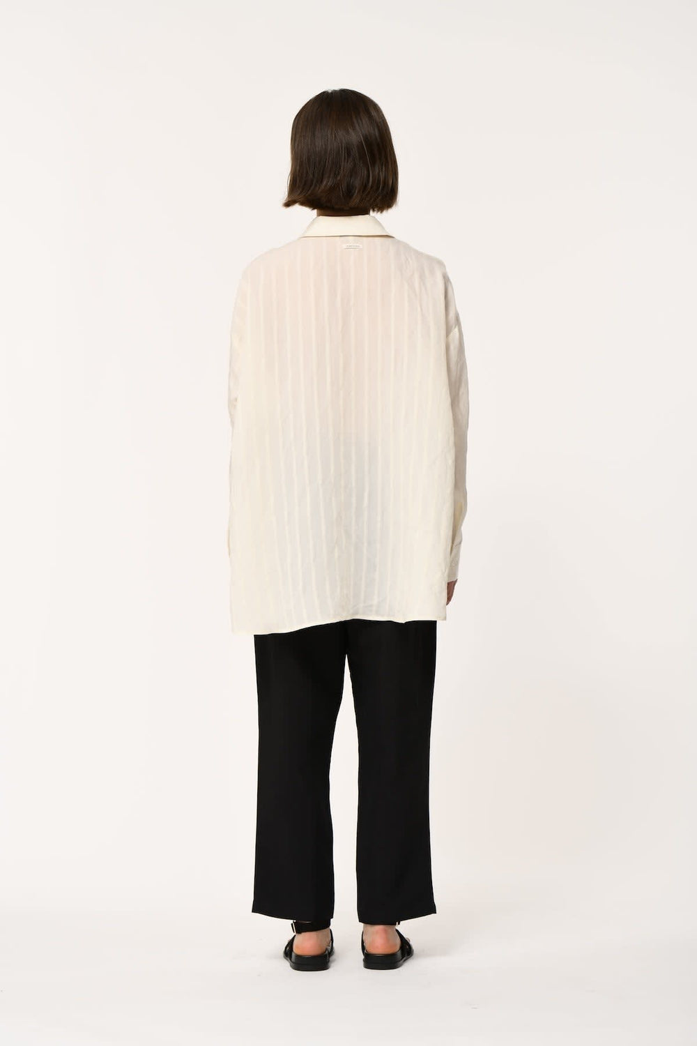 Side view of a blue striped women's shirt Humility with a collar, worn by Valérie Simon