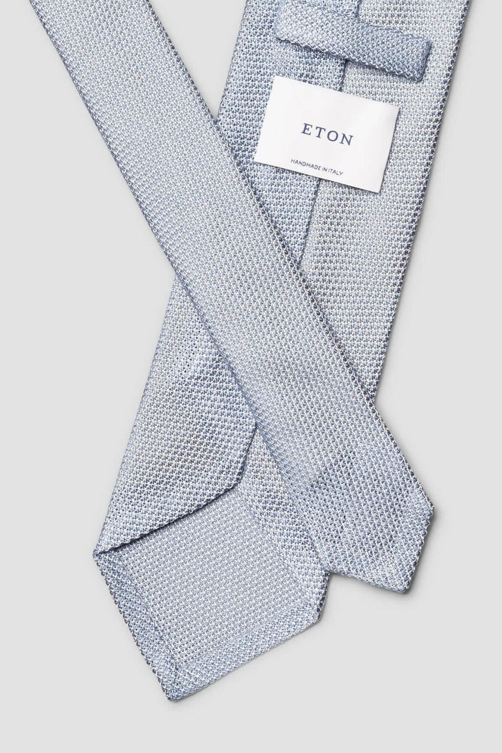 Front view of a red textured grenadine silk Eton tie with close-up details of the pattern - Valérie Simon