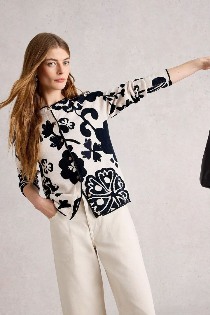 Cardigan Lulu en maille avec imprimé floral noir et blanc, porté avec un pantalon clair pour un look élégant.