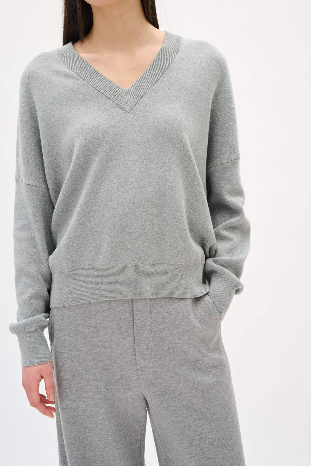 Chandail en coton gris à col en V, coupe décontractée, parfait pour un look moderne et confortable au quotidien.