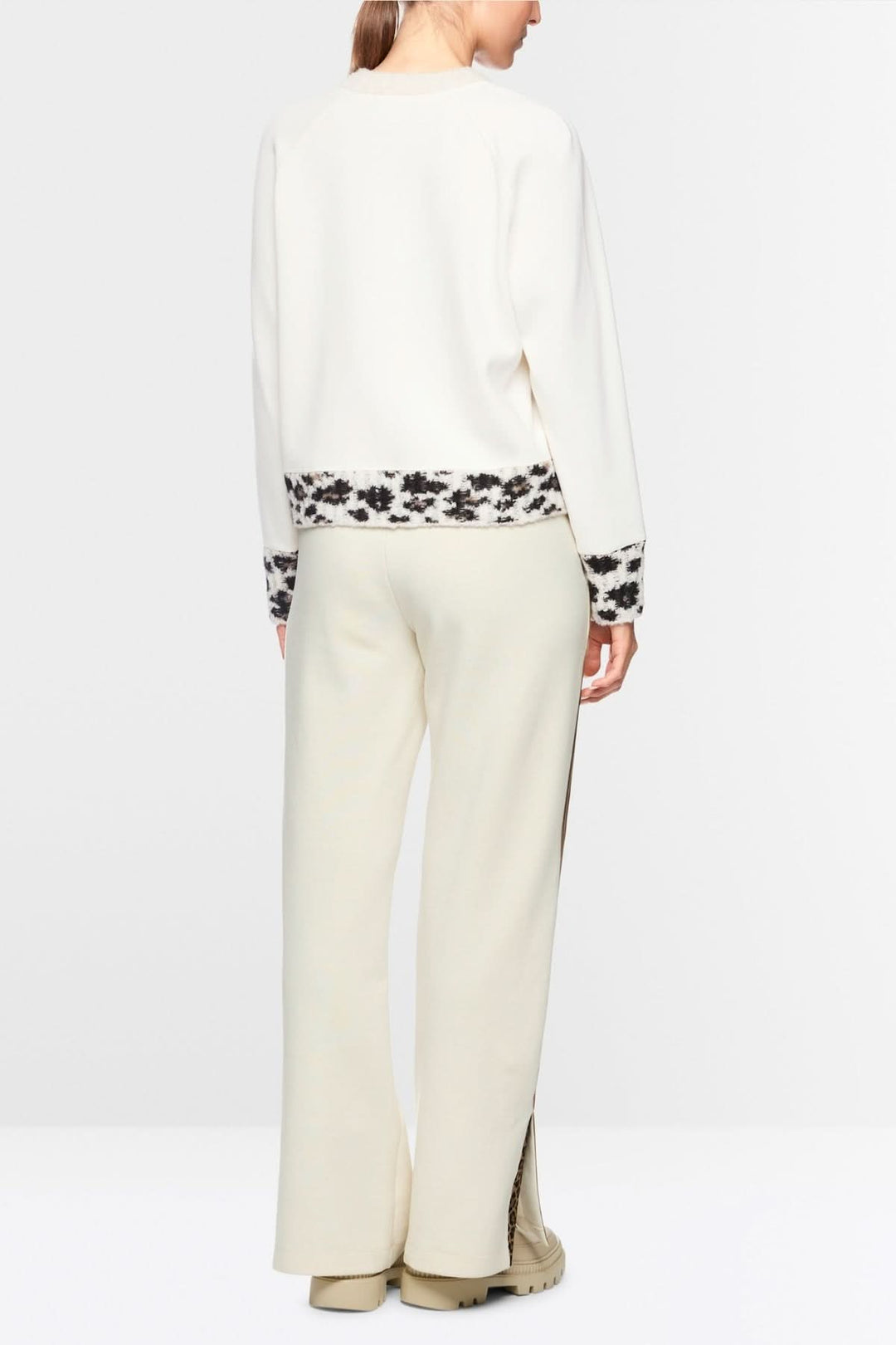 Femme portant un chandail motif graphique à manches longues avec empiècements tricotés et finitions contrastées.