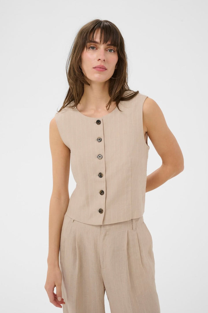 Femme portant une Veste sans manches Azania avec motif rayé et fermeture boutonnée, tenue moderne et élégante pour un look contemporain.