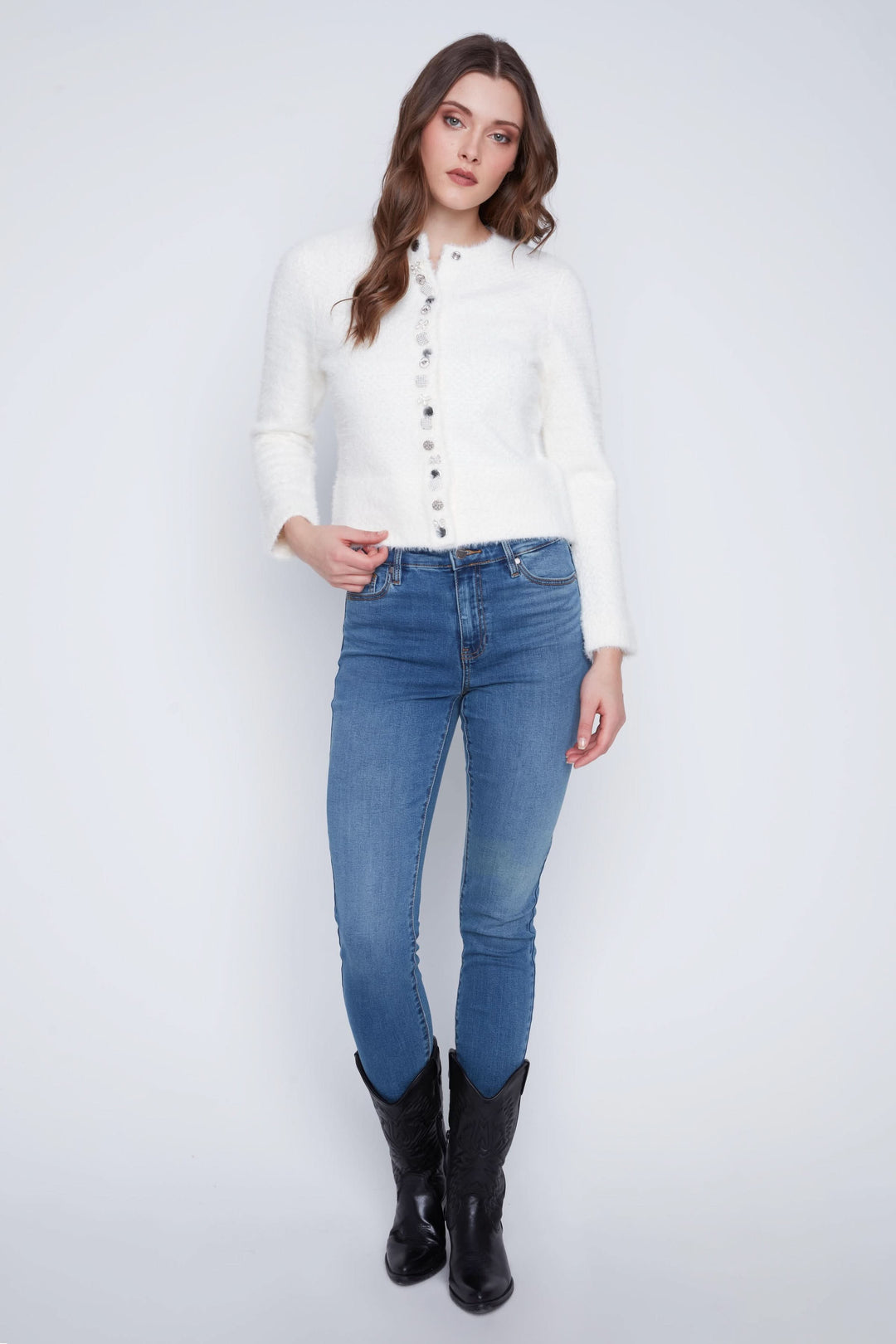 Cardigan doux à manches longues, boutons décoratifs, porté avec jeans et bottes pour un look chic.