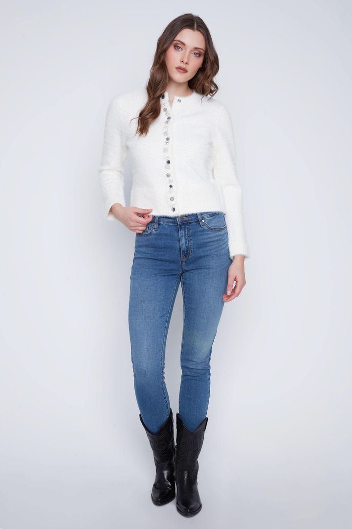 Cardigan doux à manches longues, boutons décoratifs, porté avec jeans et bottes pour un look chic.