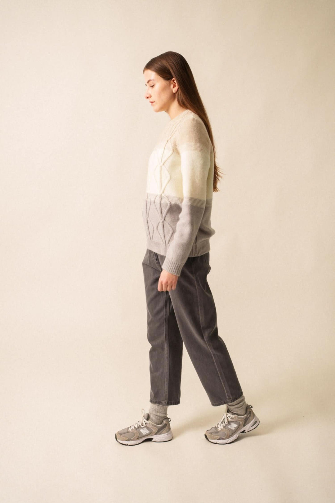 Pull en mohair structuré, dégradé de couleurs, associé à un pantalon gris et des sneakers, stylé et moderne.