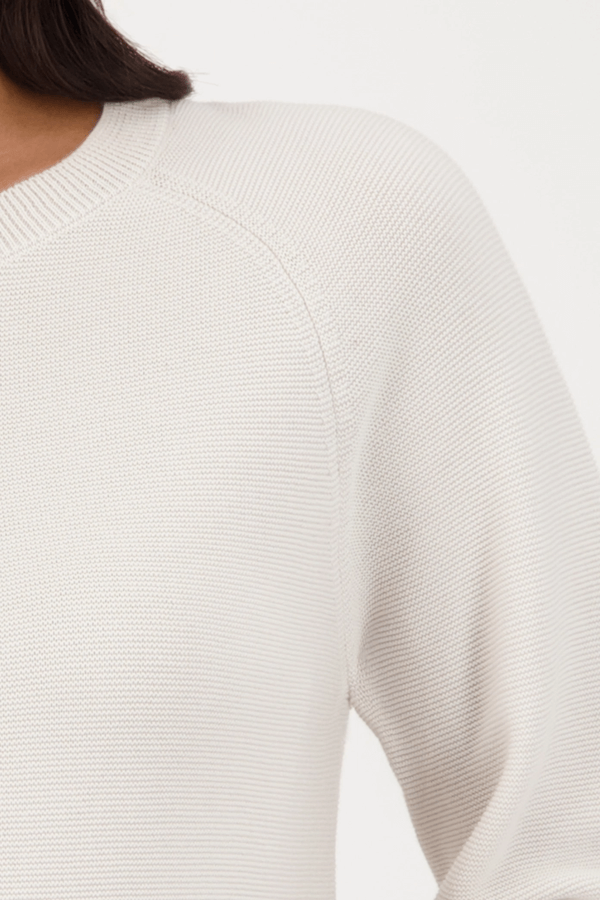 Chandail en coton tricoté avec manches légèrement bouffantes resserrées aux poignets, coupe droite et encolure ronde classique.