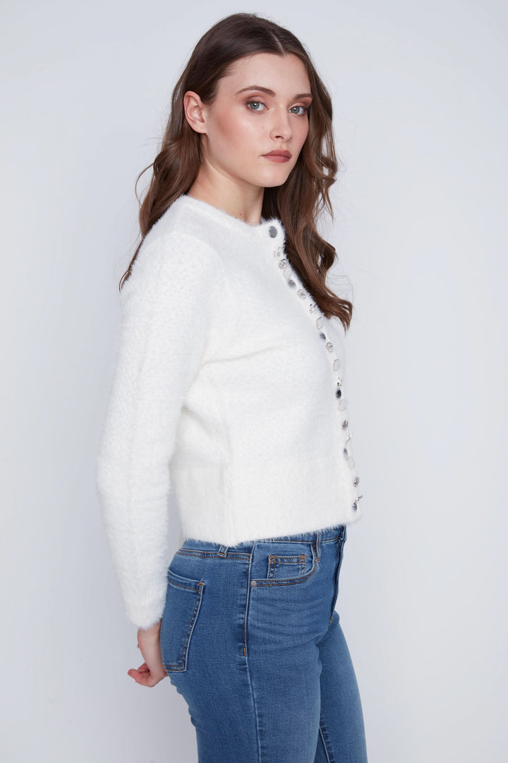 Cardigan doux à manches longues, coupe courte et ajustée, avec boutons décoratifs, porté avec un jean.