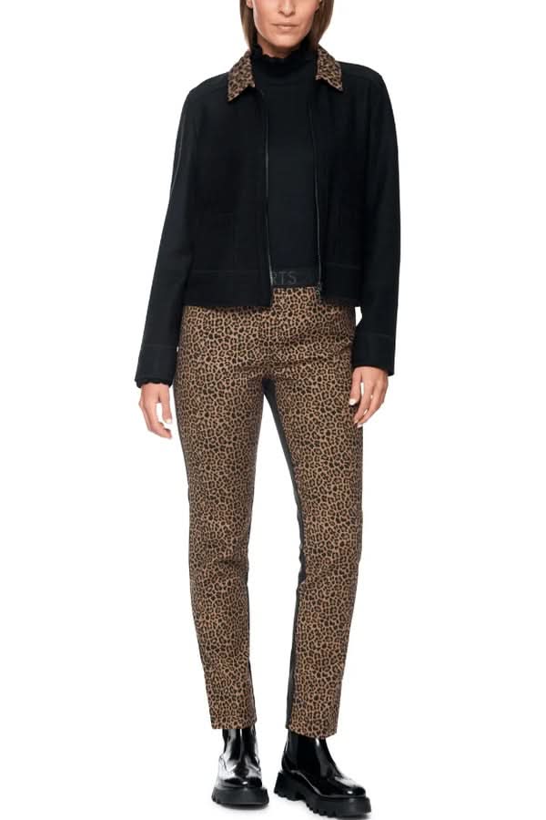 Femme portant un pantalon ajusté à imprimé animalier avec bandes unies, coupe slim, et taille élastique pour confort et style.