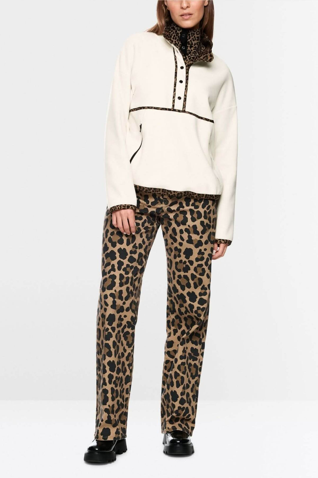 Chandail col montant avec patte de boutonnage, détails contrastés et imprimés, porté avec pantalon imprimé léopard.