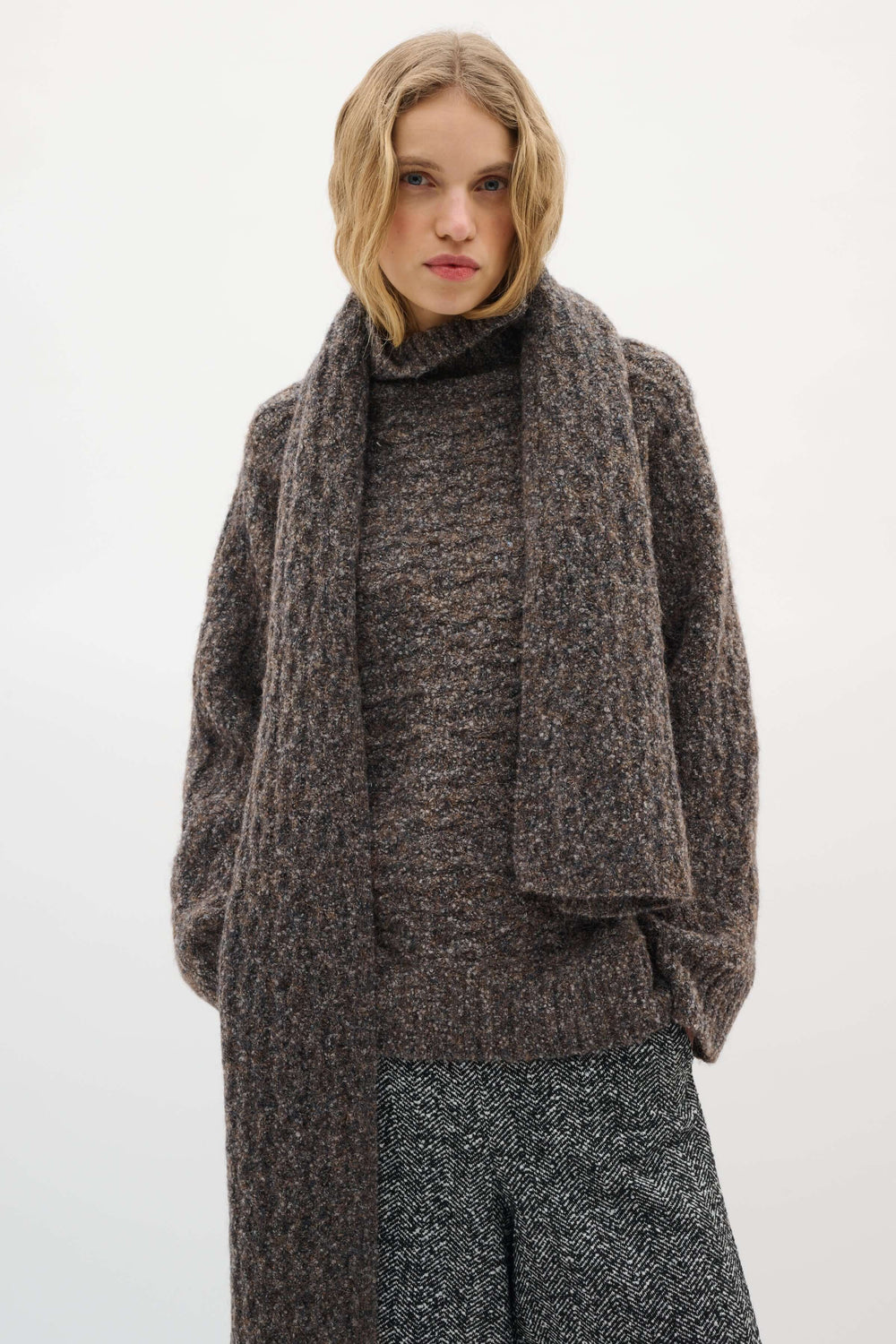 Femme portant le Foulard Graia en maille texturée pour un style moderne et confort durant la saison froide.