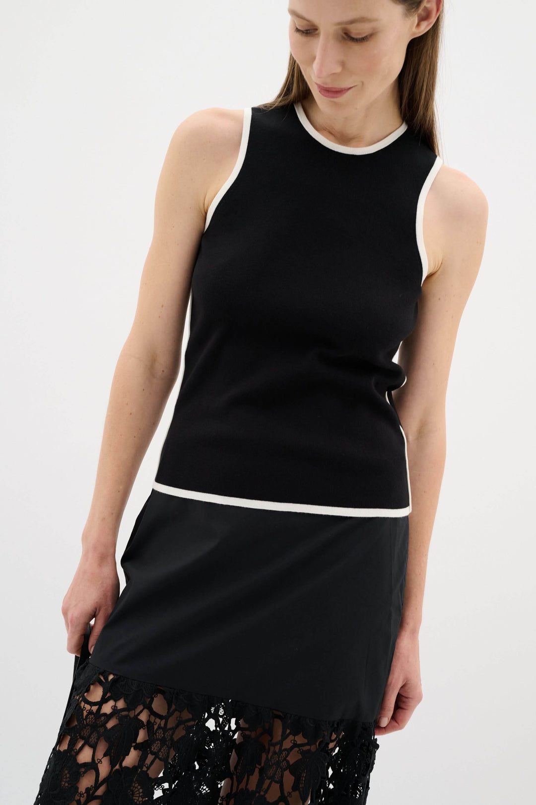 Camisole noire sans manches avec encolure ronde et liseré contrastant, style minimaliste et raffiné.