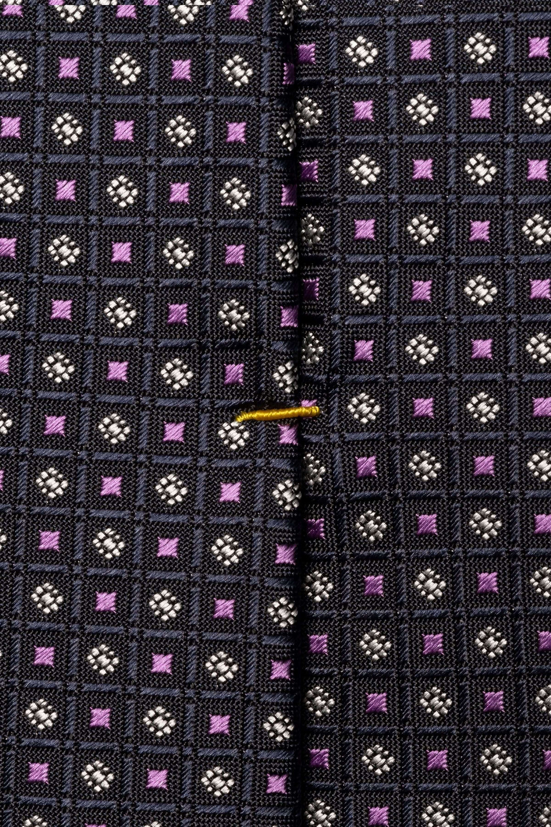 Cravate motif géométrique avec texture légèrement satinée et design à carreaux colorés.