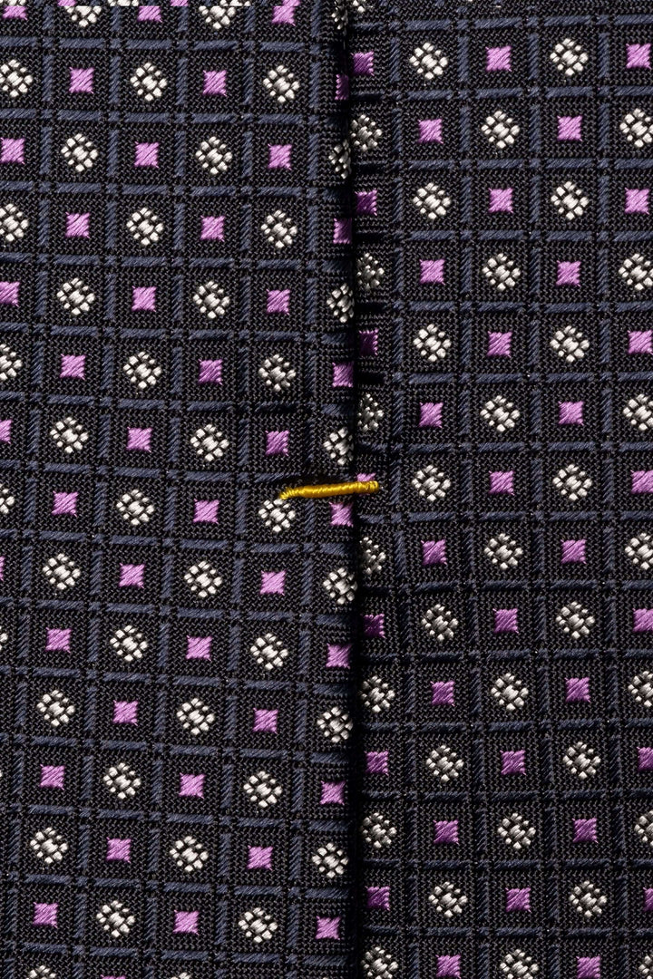 Cravate motif géométrique avec texture légèrement satinée et design à carreaux colorés.