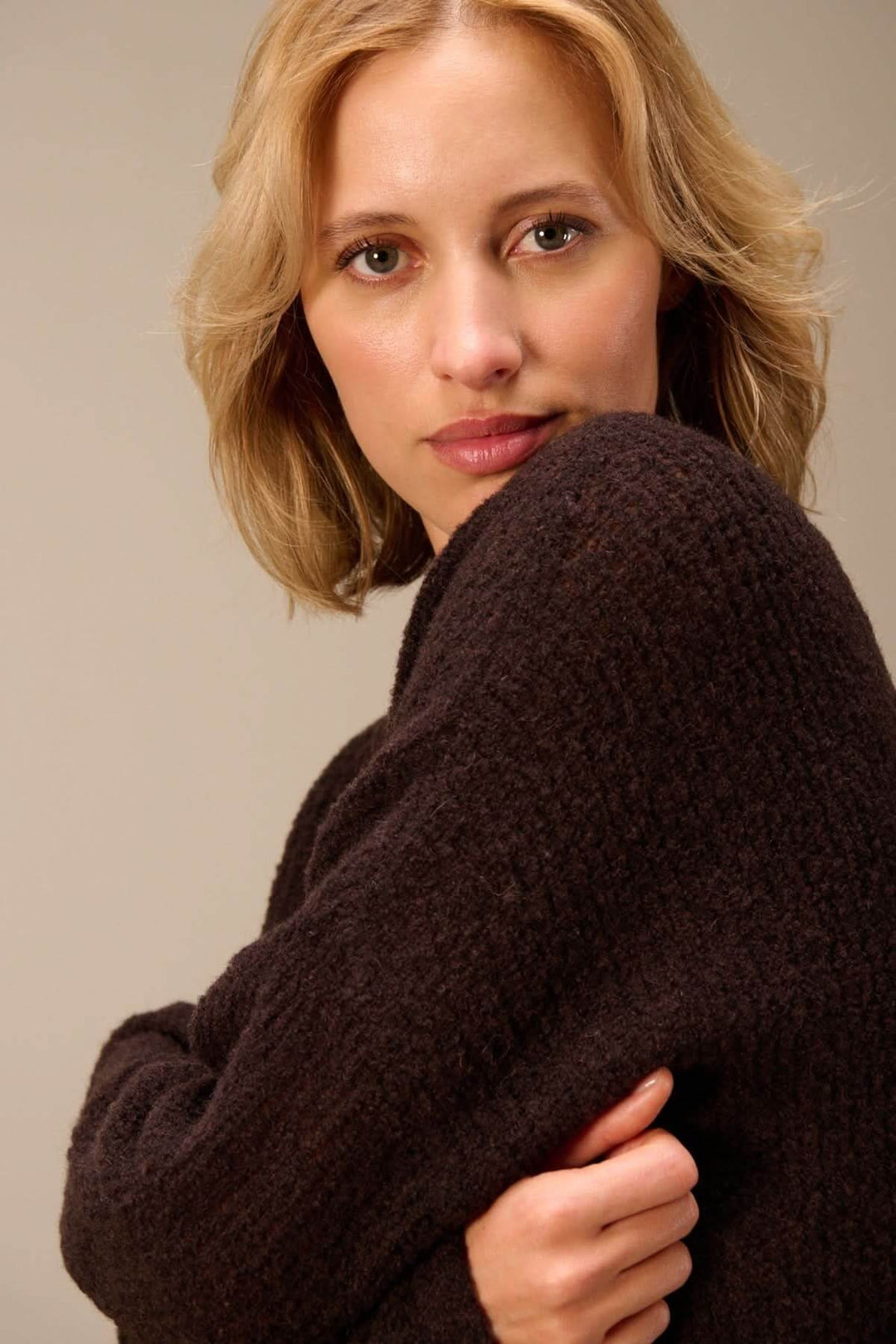 Femme portant un chandail ample en laine mérinos texturée avec manches longues et col rond, pour un style moderne et décontracté.