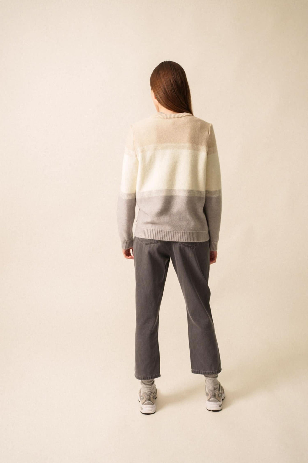 Pull en mohair structuré gris et crème, vu de dos, porté avec un pantalon gris et des baskets blanches.