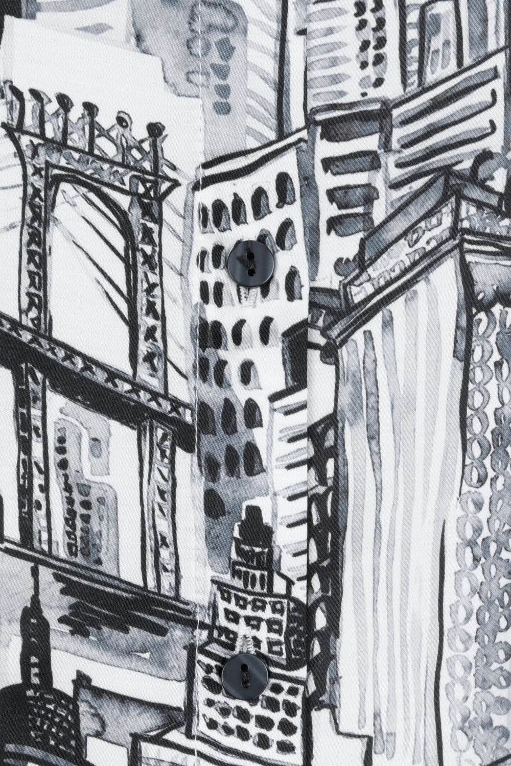 Imprimé graphique urbain en noir et blanc sur blouse, représentant des bâtiments et la skyline d'une ville moderne.