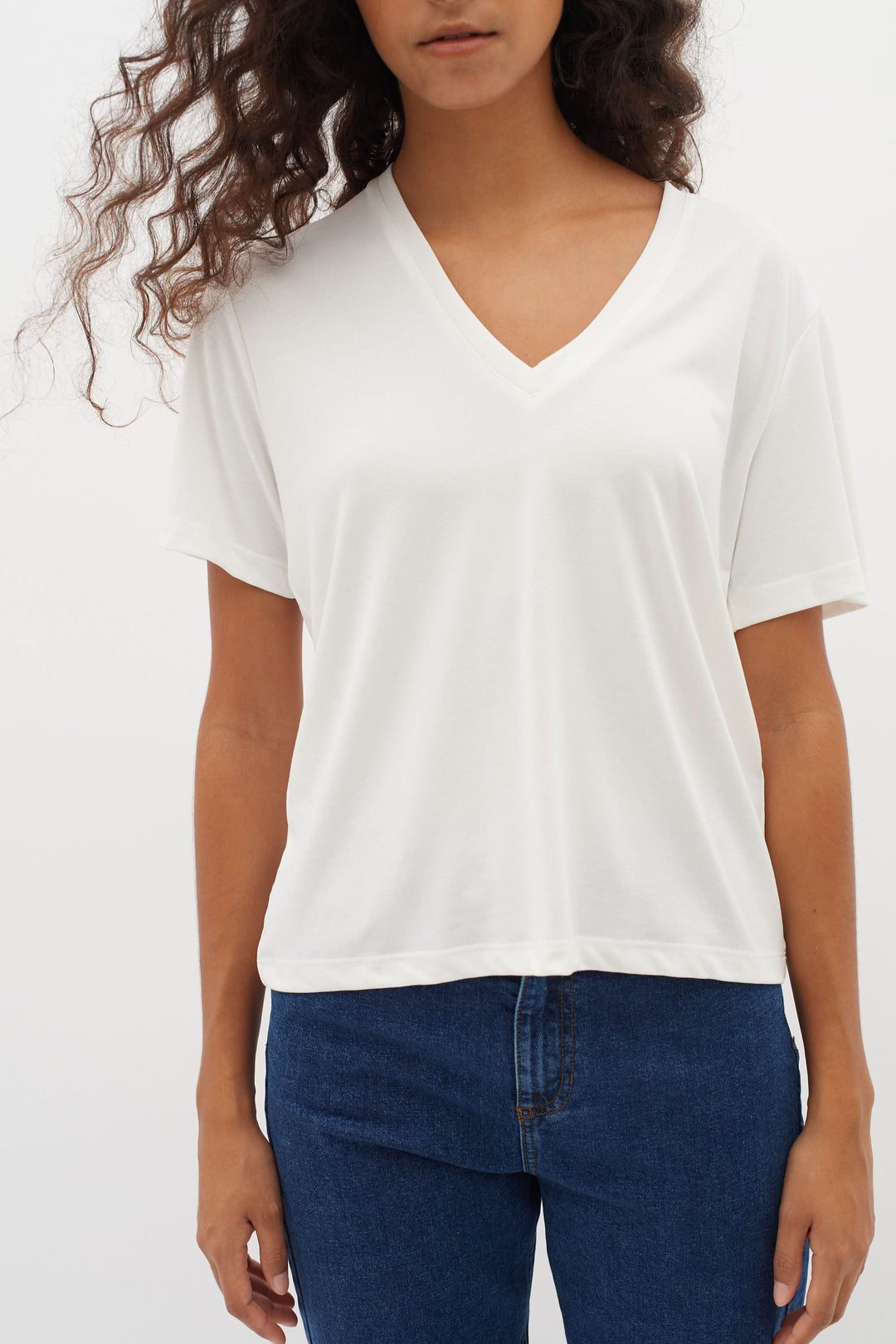 T-shirt col en V Liliana blanc porté par une femme, coupe droite et manches courtes, matière douce pour confort quotidien.
