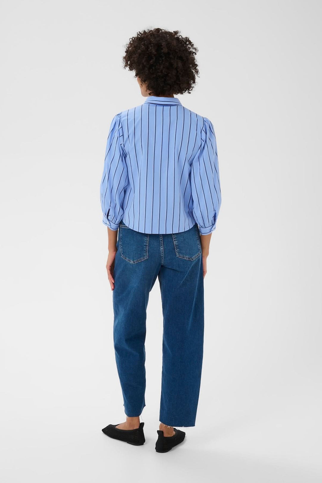 Vue arrière de la Blouse rayée Anais, manches bouffantes, associée à un jean, élégante et polyvalente.