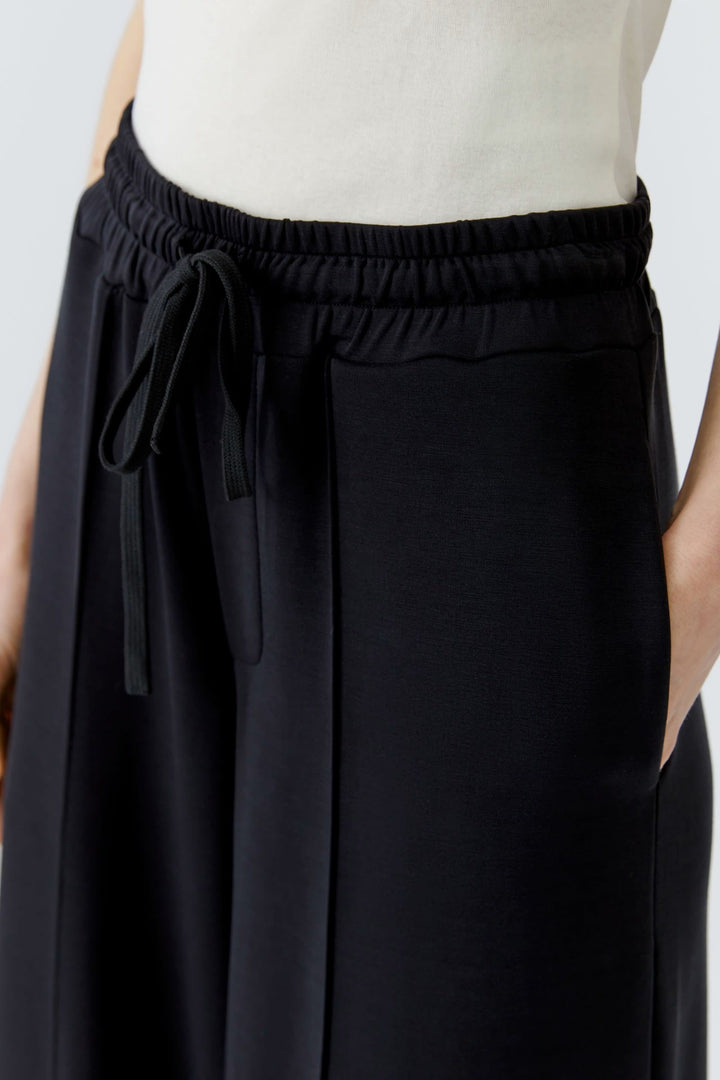 Vue de côté pantalon large noir à taille élastique Oui pour femme - Valérie Simon