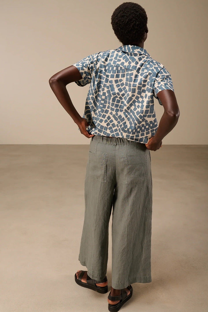 Side view of wide-leg beige linen pants with pleats and a Nile braided waistband for women - Valérie Simon
