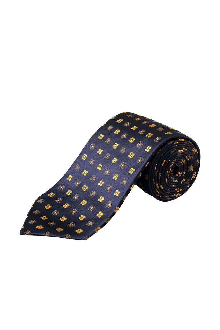 Cravate à motifs floraux géométriques sur fond bleu marine, ajoutant élégance à un costume.