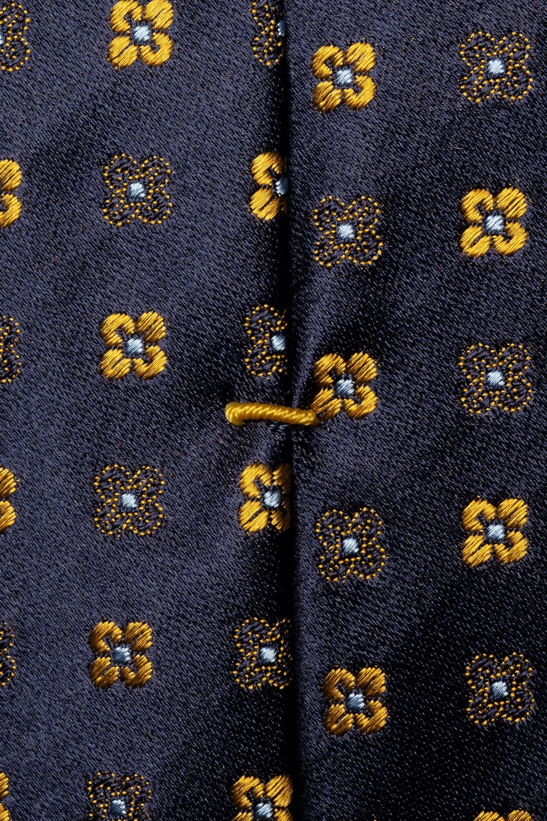 Cravate à motifs floraux géométriques en tissu avec finition lisse et brillance.